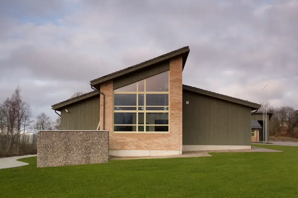 Modernes Gebäude mit großer Glasfront und Rasenfläche