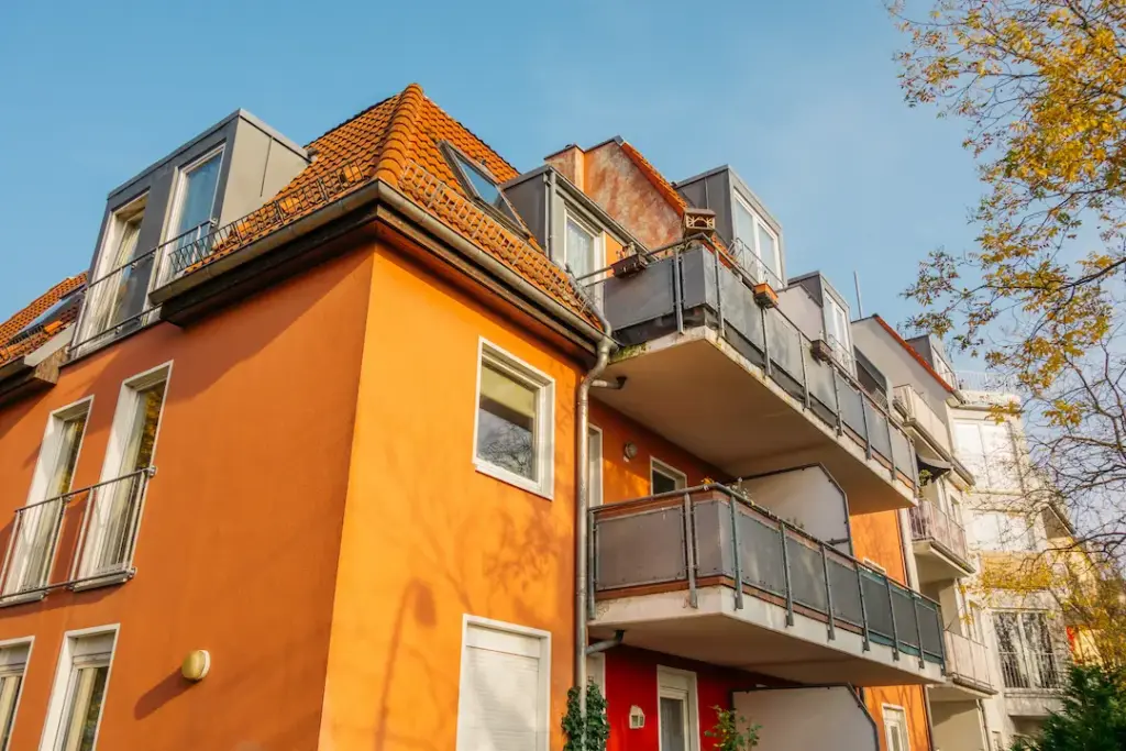 Mehrfamilienhaus mit orangefarbener Fassade und Balkonen